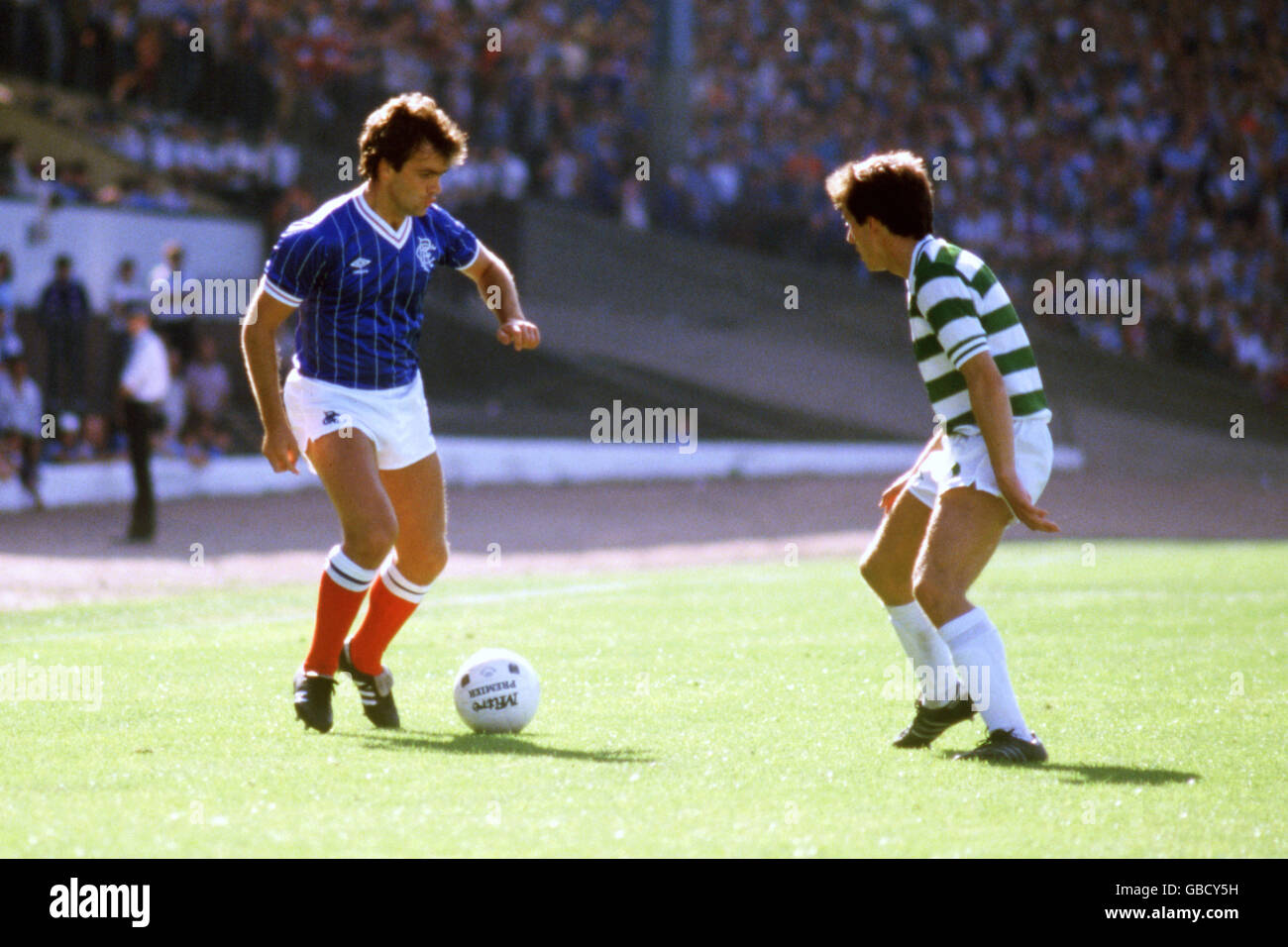 Rangers' Davie Cooper (l) takes on Celtic's Mark Reid (r) Stock Photo