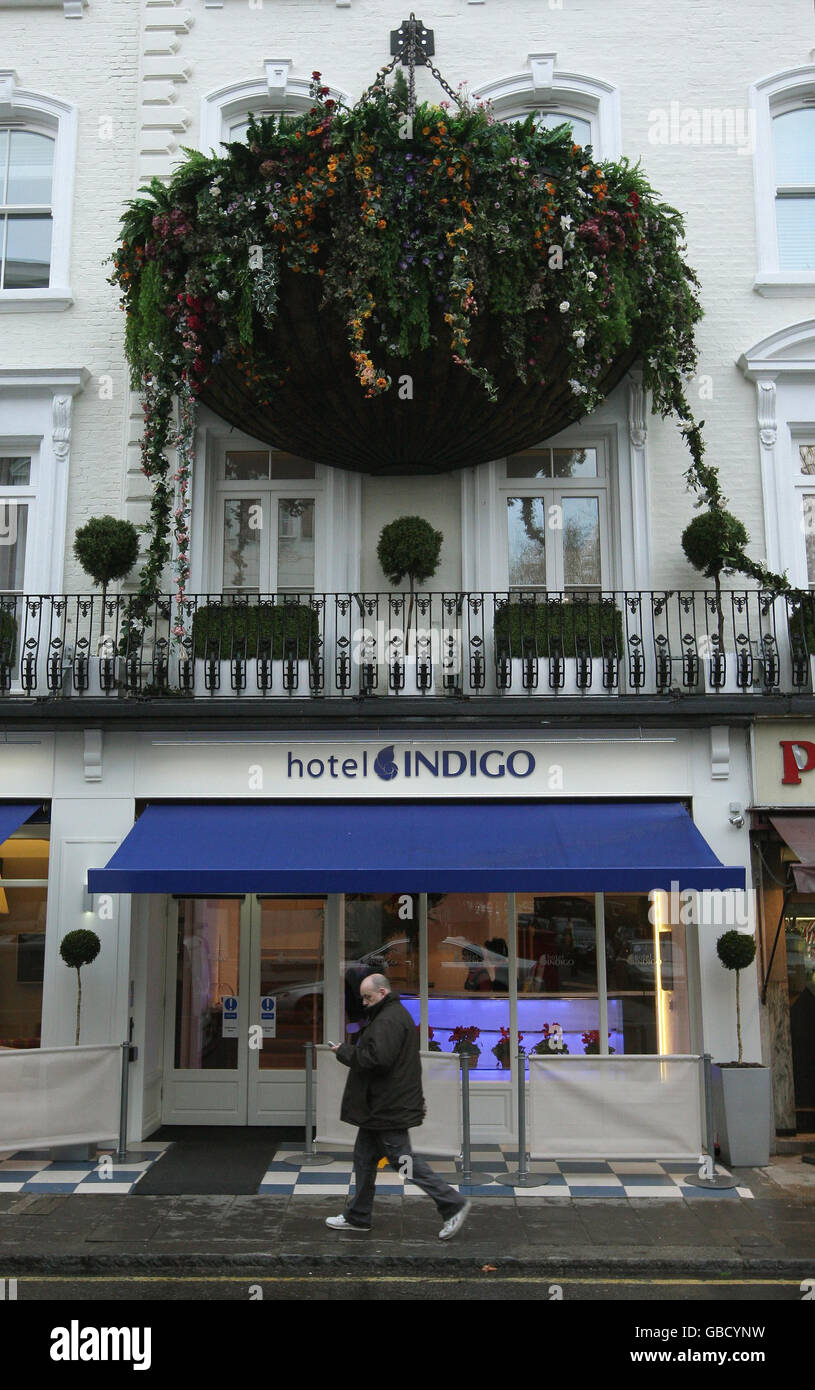 A pedestrian walks underneath a giant hanging basket outside Hotel