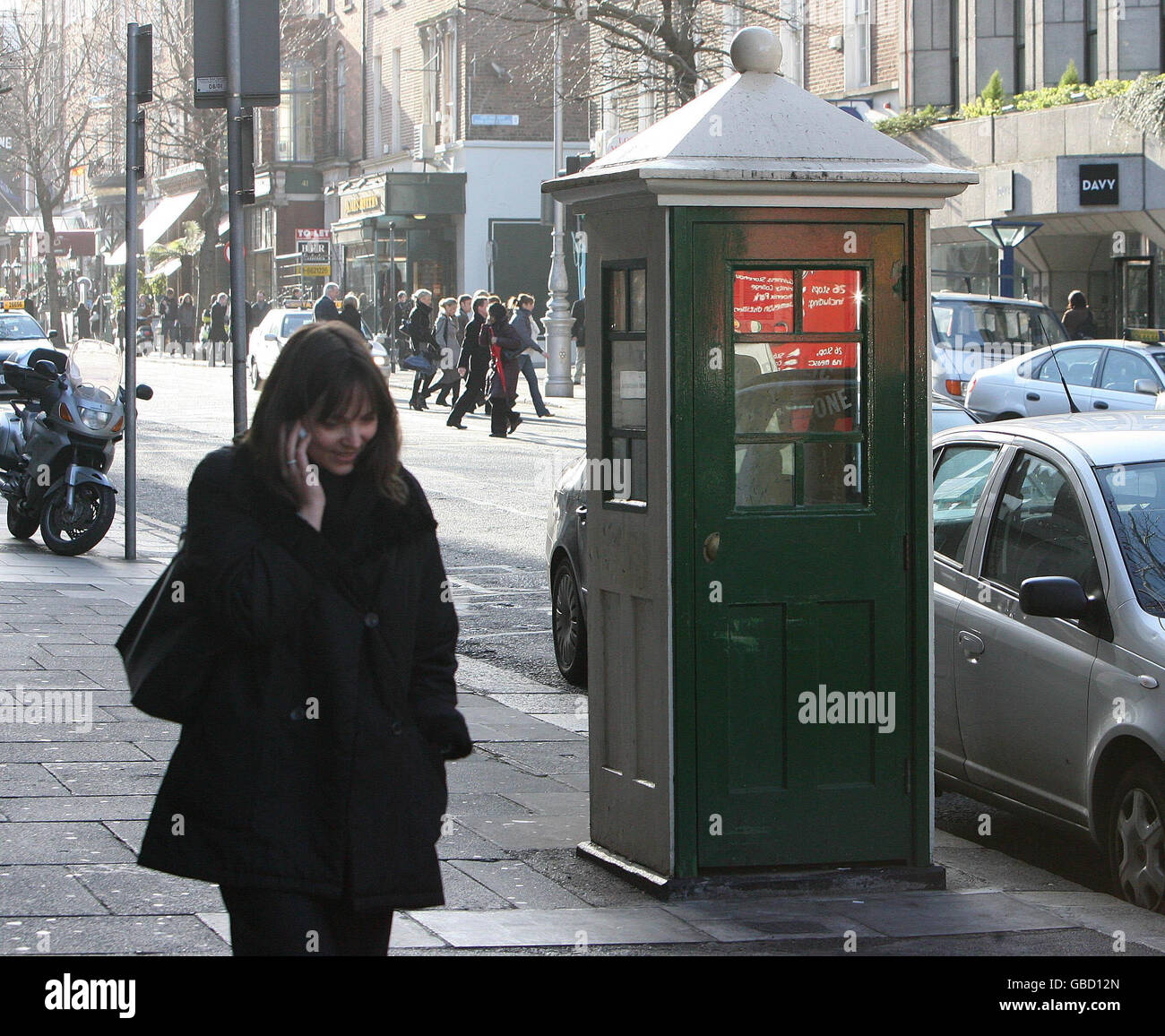 Half of Irish payphones to be removed. A member of the public walks past a phone box in Dublin's city centre which is believed to be 84-years-old. Stock Photo