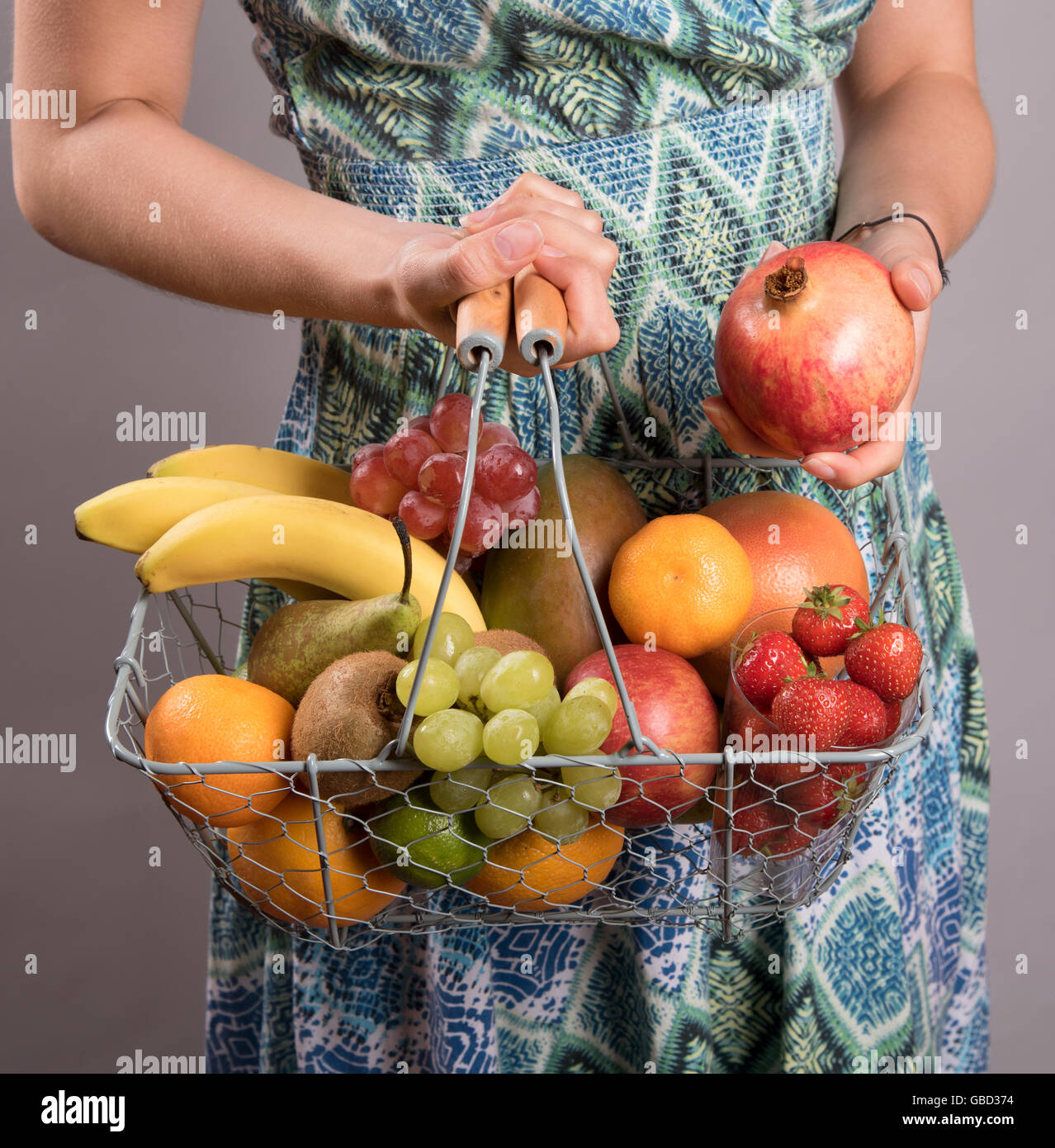 Woman holding shopping basket of fresh fruit Stock Photo - Alamy