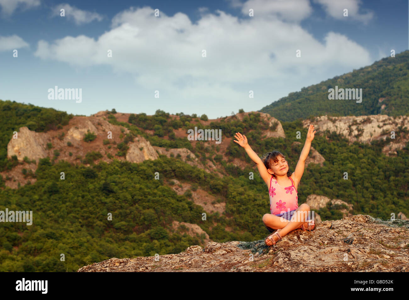 happy little girl with hands up on mountain top Stock Photo - Alamy