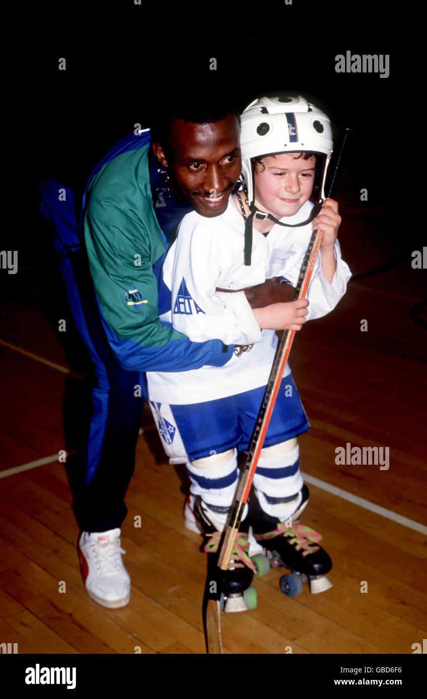 Sprinter Linford Christie tickles a young roller hockey player Stock Photo