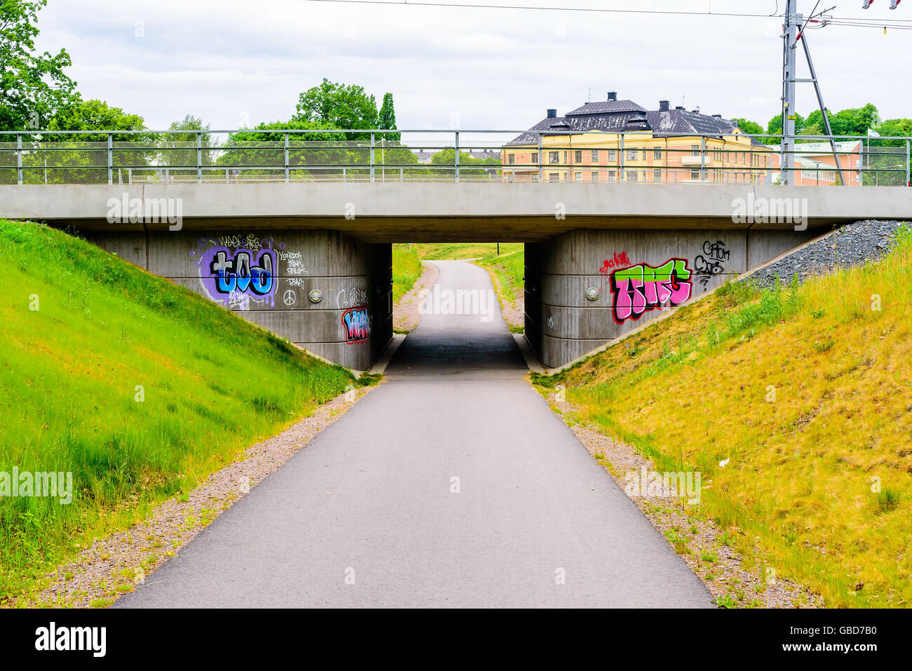 Motala, Sweden -June 21, 2016: Graffiti painted on either sides of a viaduct passing over a walkway. Stock Photo