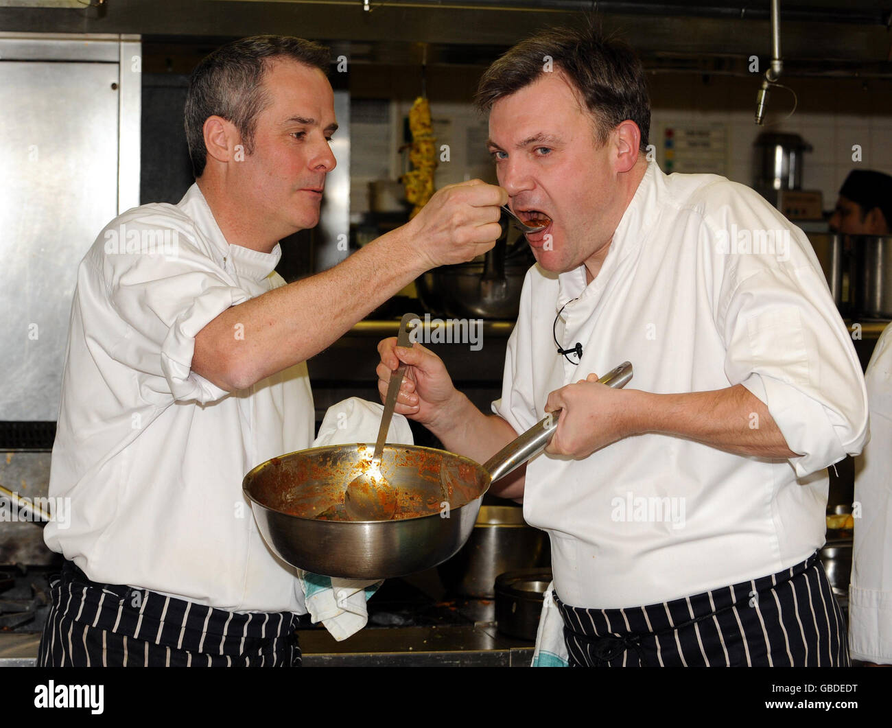 Schools secretary Ed Balls (right) and television chef Phil Vickery, in the kitchen of the Cinnamon Club restaurant in Westminster, central London, preparing a curry from a recipe book which is to be distributed to the nation's schoolchildren as part of a government drive encouraging children to cook. Stock Photo