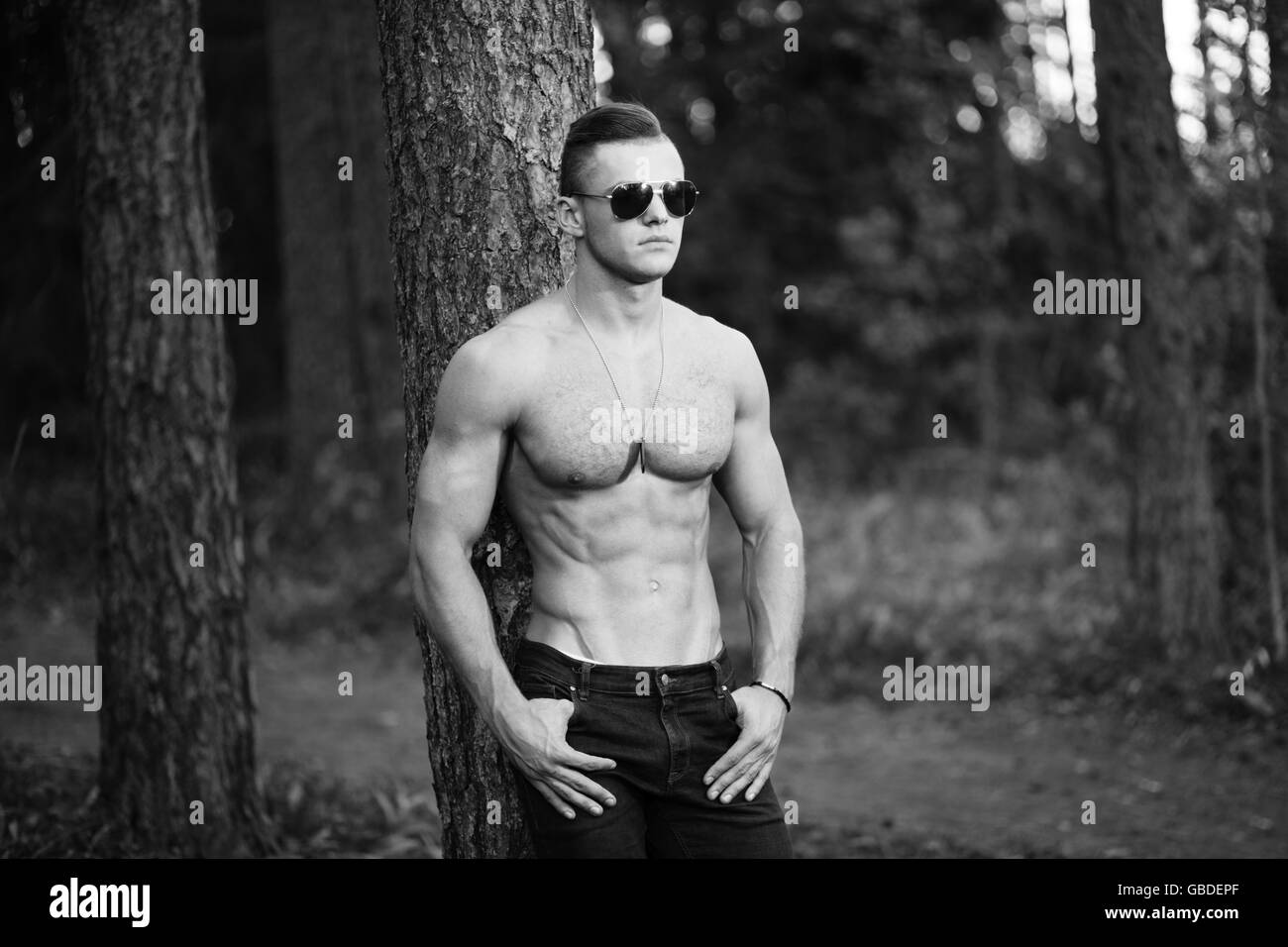 BW outdoor portrait of muscular young man in sunglasses. Stock Photo