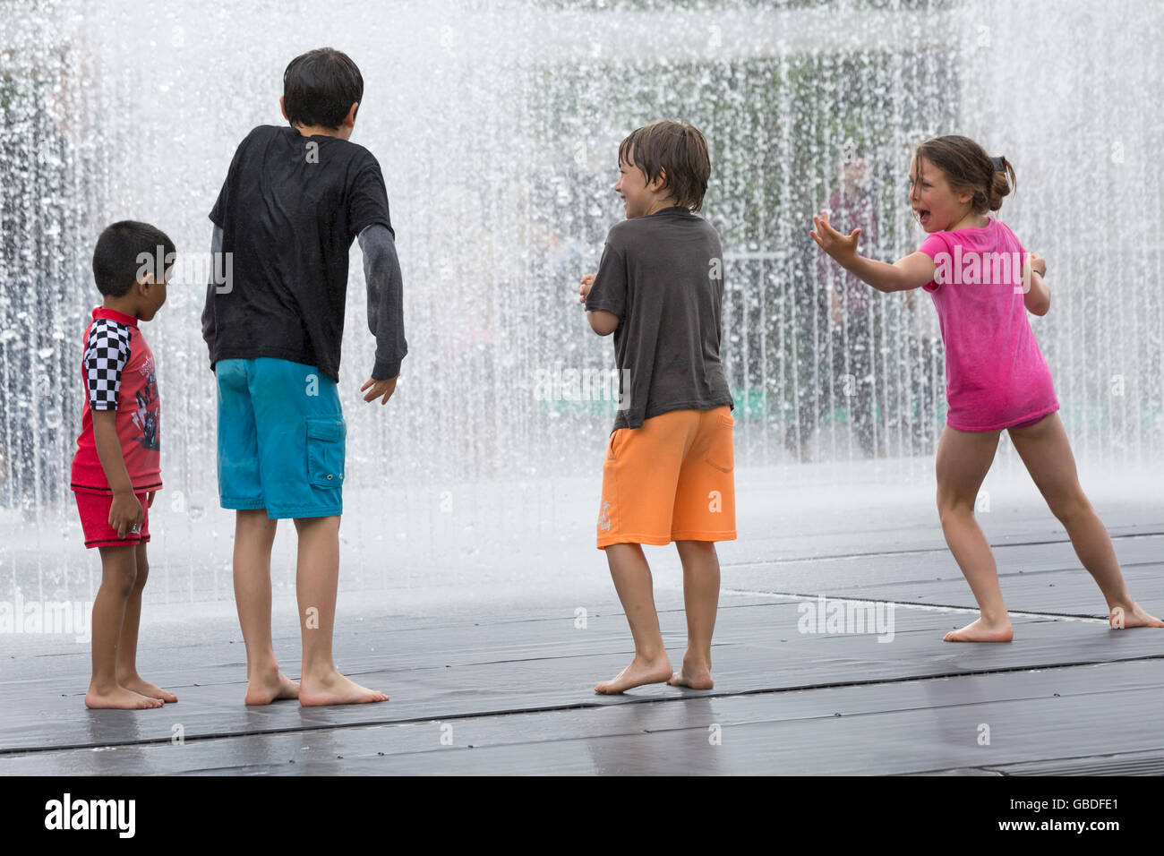 Children playing in water feature at Southbank, London in July Stock Photo