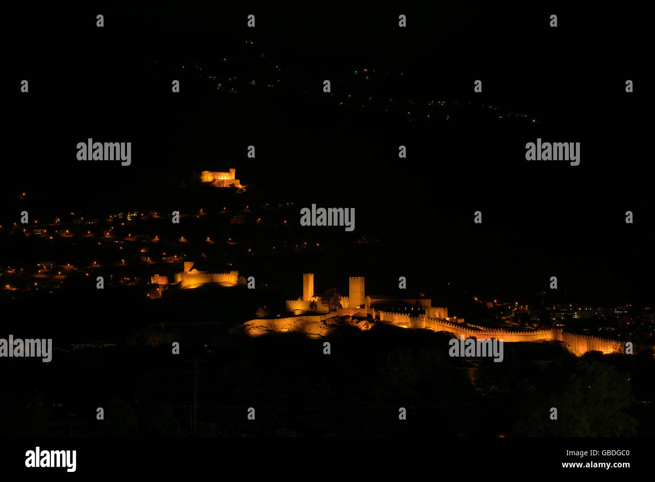 The three castles of Bellinzona (Castelgrande, Montebello, Sasso Corbaro) at night. Canton of Ticino, Switzerland. Stock Photo