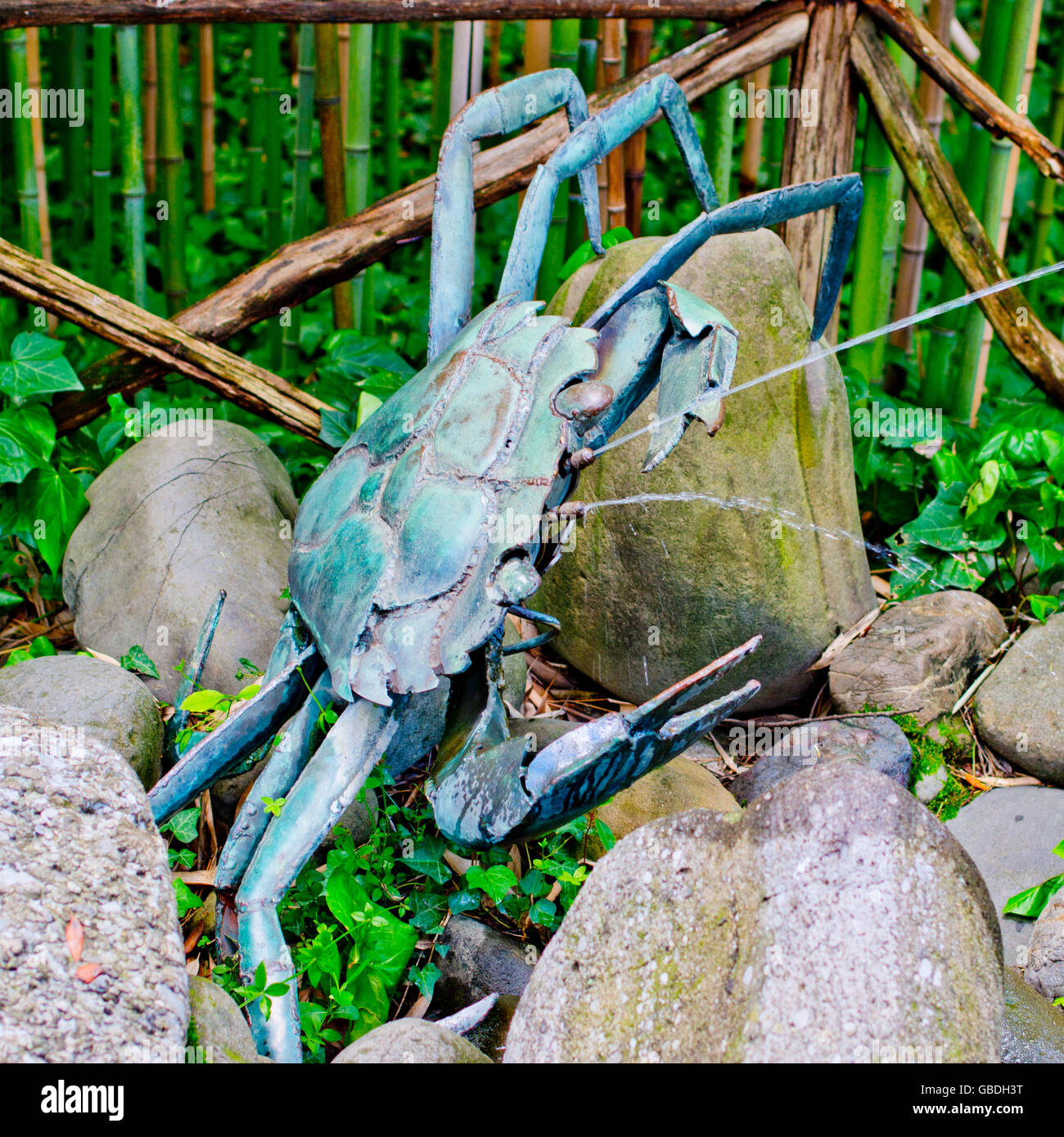 metal sculpture crabs partially oxidized sprays water to passers-by a forest of bamboo canes Stock Photo