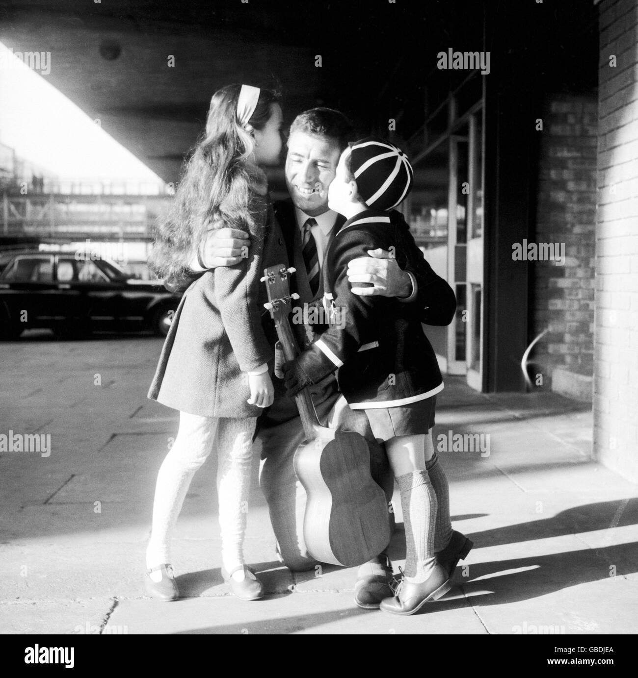 England vice-captain Fred Titmus is hugged by his children Dawn and Mark upon his return from the West Indies, where he lost four toes in a boating accident Stock Photo