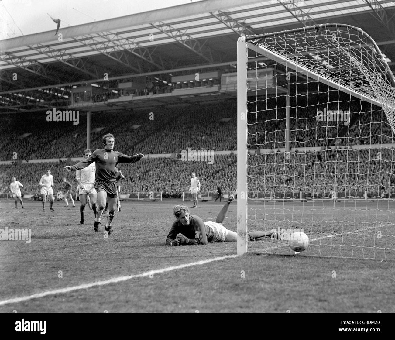 Leeds United goalkeeper Gary Sprake (r) looks back in despair at the ball after he let a soft shot from Chelsea's Peter Houseman (third l, background) sneak under his body for the opening goal. Chelsea's Tommy Baldwin (c) begins to celebrate Stock Photo