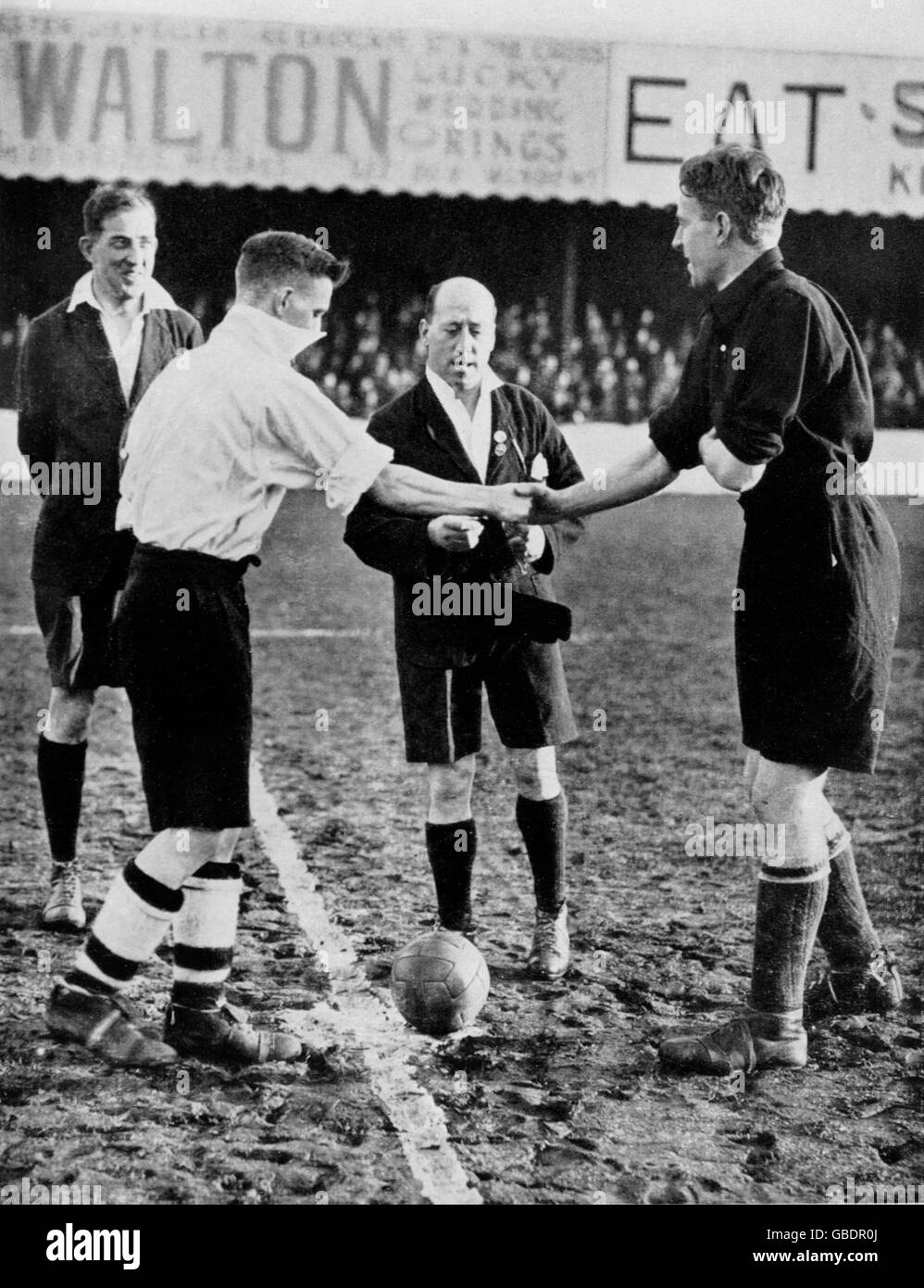 Two referees, Dr AW Barton (l) and E Wood (second r), oversee the coin toss at Chester. This was one of a series of games in which the FA experimented with having two referees controlling the match - the idea was dropped at the start of the 1935-36 season Stock Photo