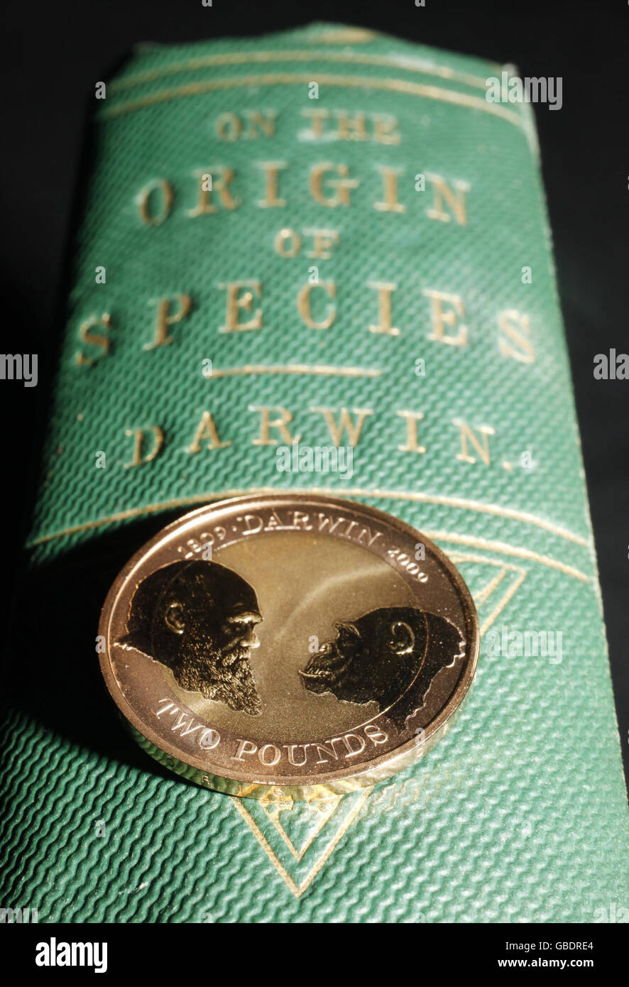 The Royal Mint's new special, collectable 2 coin on the spine of a first edition of Charles Darwin's 'On The Origin Of The Species' in the Rare Books Room at the Natural History Museum in London, which launches today to commemorate the 200th anniversary of his birth. Stock Photo