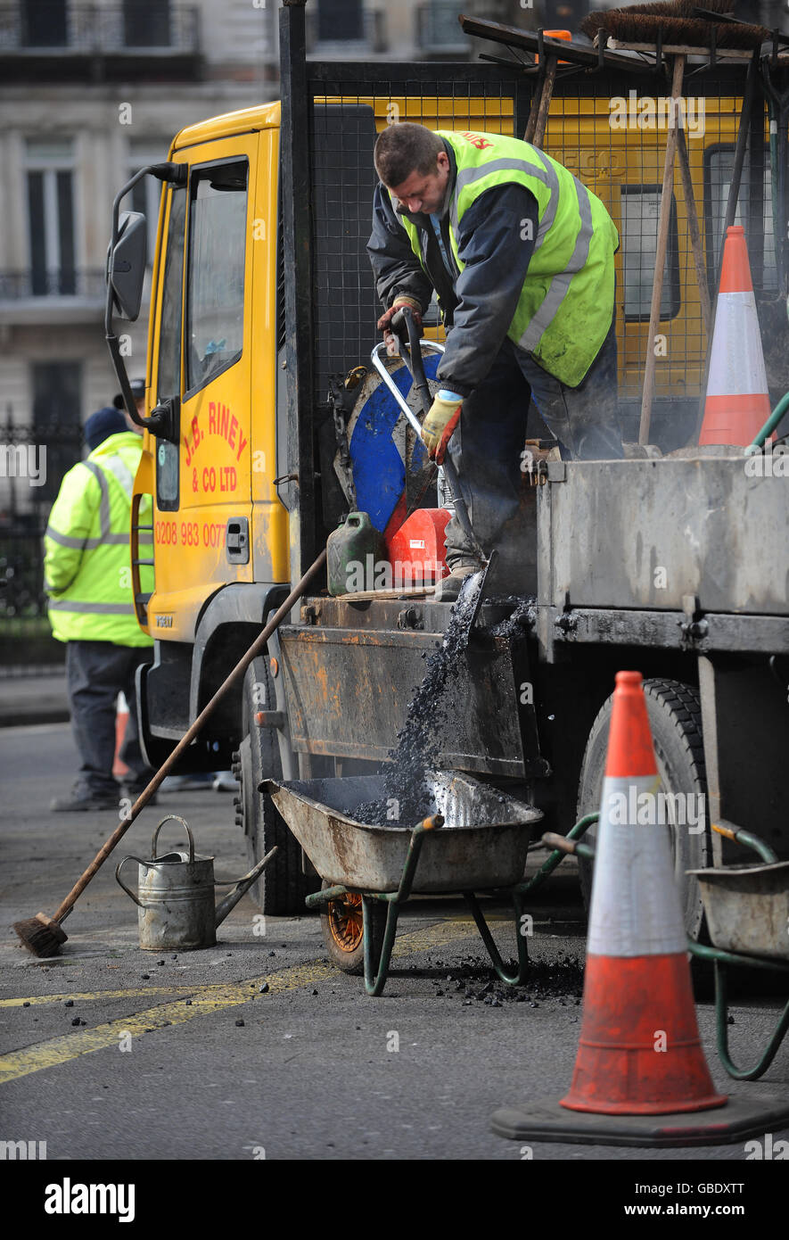 Roadworks in Cromwell Road, London by Transport for London staff. The orange plastic tubing is for housing traffic signal cabling. Stock Photo