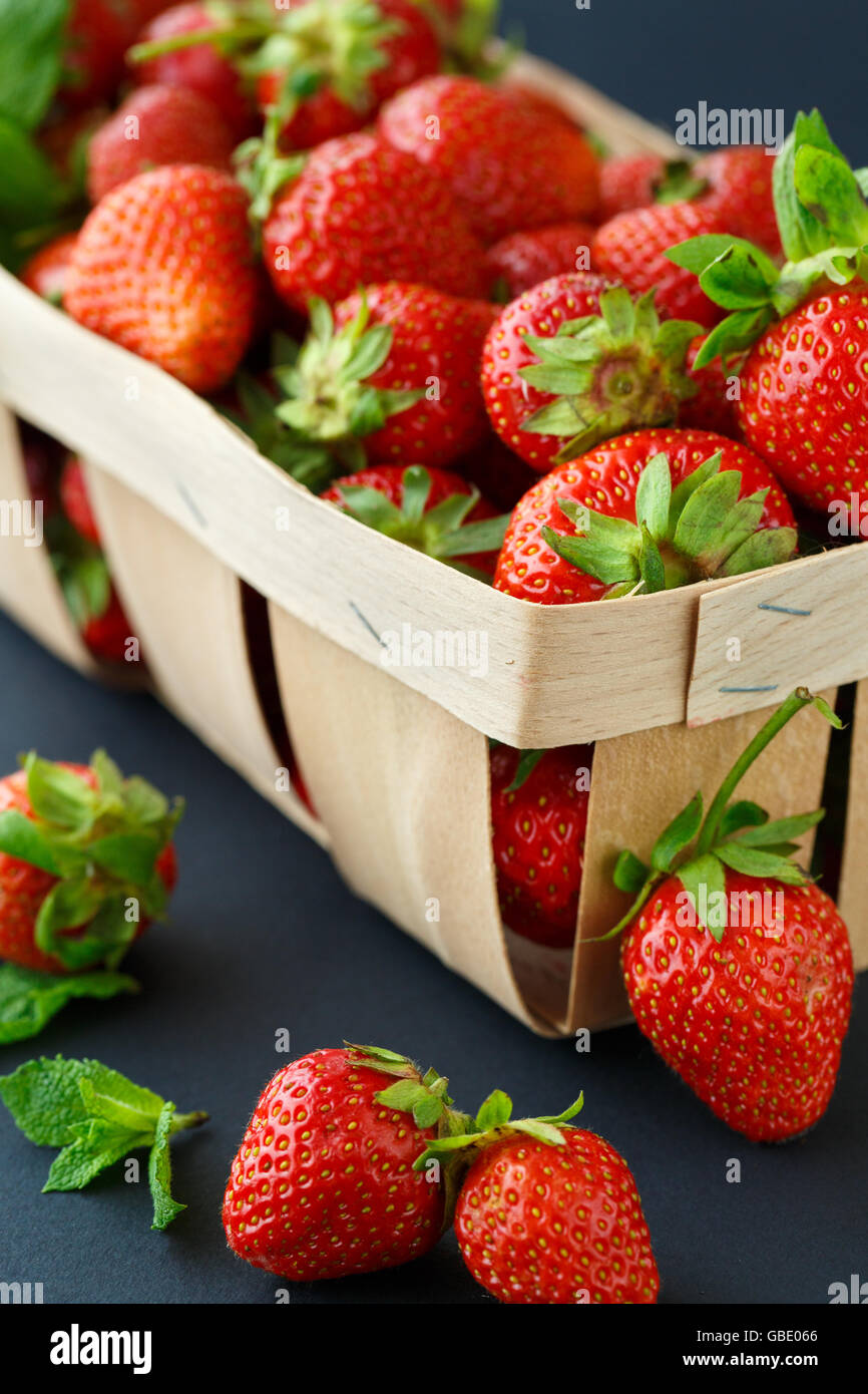Ripe strawberries in a wooden basket on black background Stock Photo ...