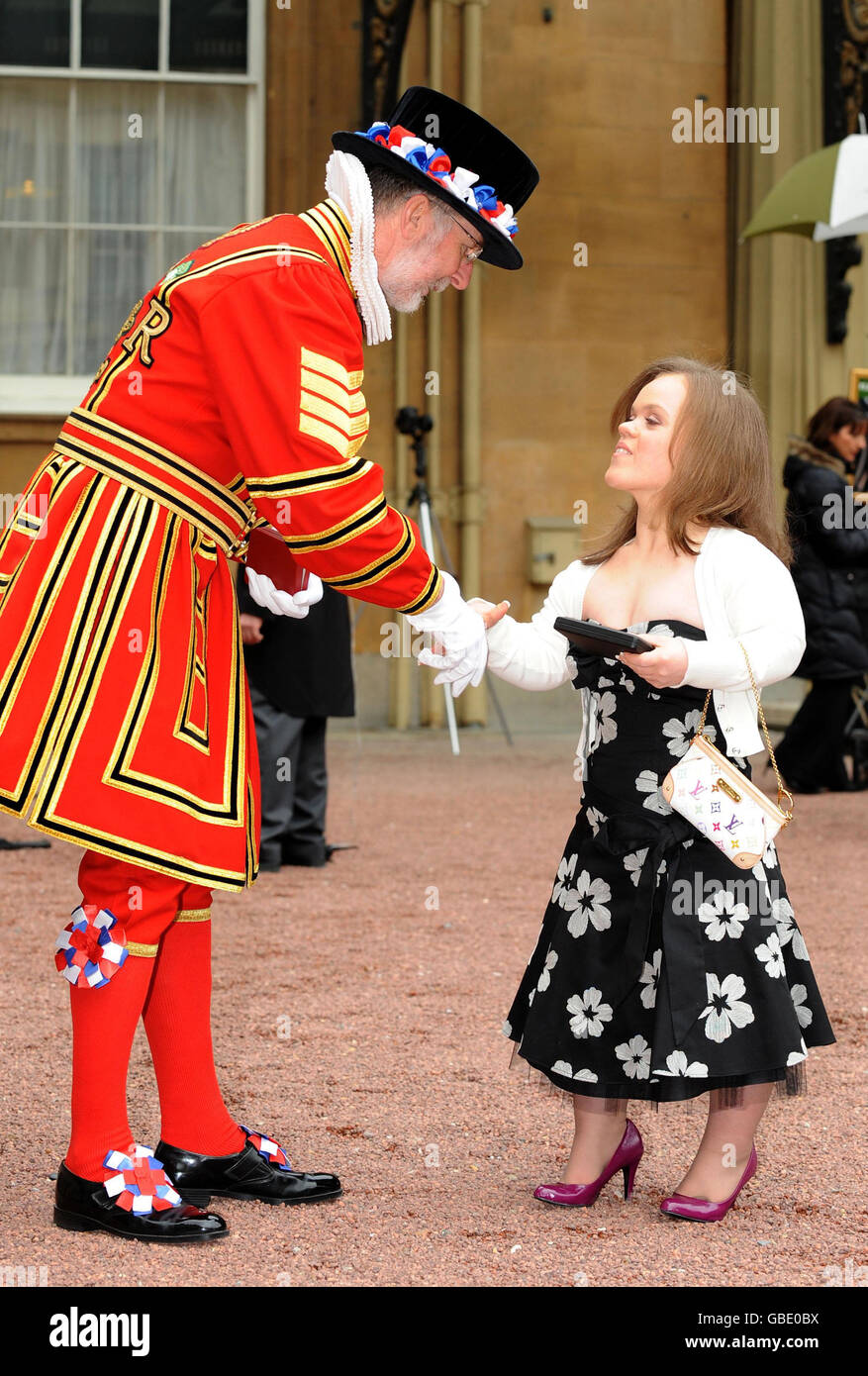 Yeoman Sergeant Roderick Truelove, who received a Royal Victorian Medal, congratulates Paralympic swimmer Eleanor Simmonds after receiving her MBE from Britain's Queen Elizabeth II at Buckingham Palace, London. Stock Photo