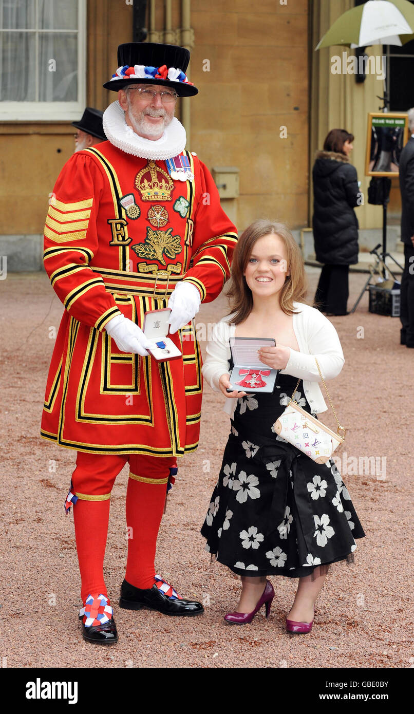Yeoman Sergeant Roderick Truelove, who received a Royal Victorian Medal, stands with Paralympic swimmer Eleanor Simmonds after she received an MBE from Britain's Queen Elizabeth II at Buckingham Palace, London. Stock Photo