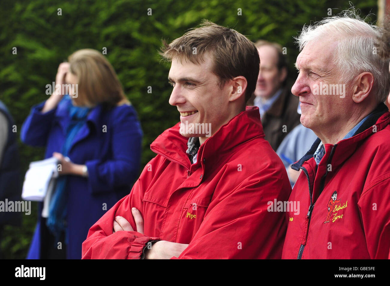 Trainer Martin Pipe with stable jockey Tom Scudamore (left) watch the horses parade at David Pipe's stables in Nicholashayne, Somerset. Stock Photo