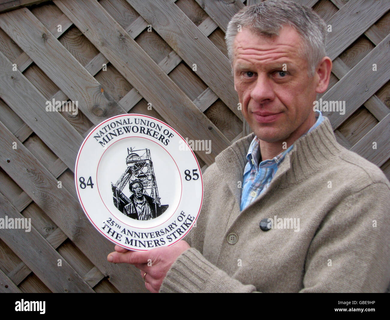 Postman Adrian Loftus with the commemorative plate he created to mark