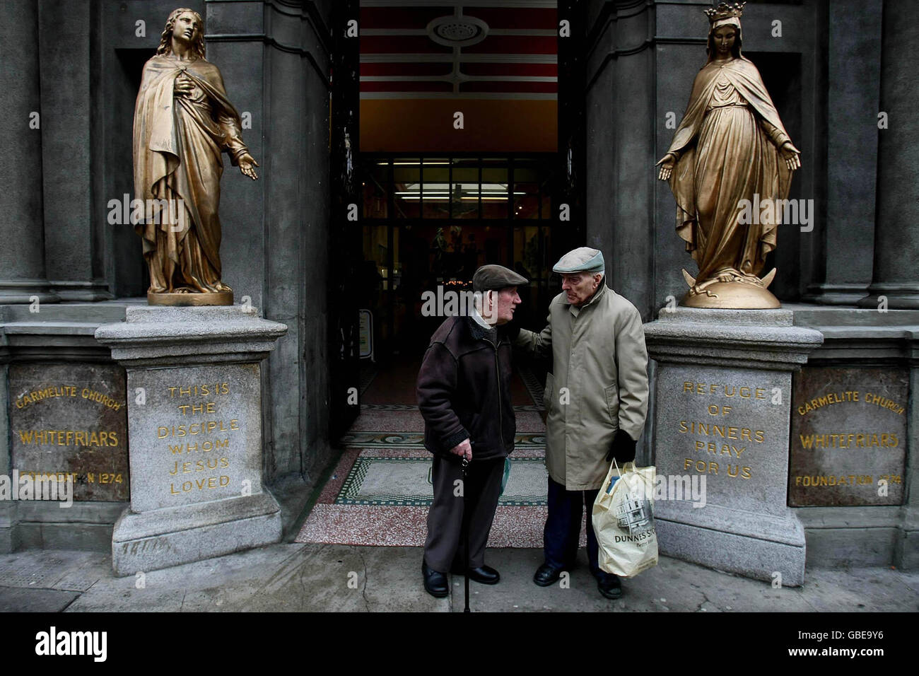 Two elderly gentlemen have a quiet chat after mass outside the Whitefriars Carmelite Church on Aungier Street, Dublin. Stock Photo