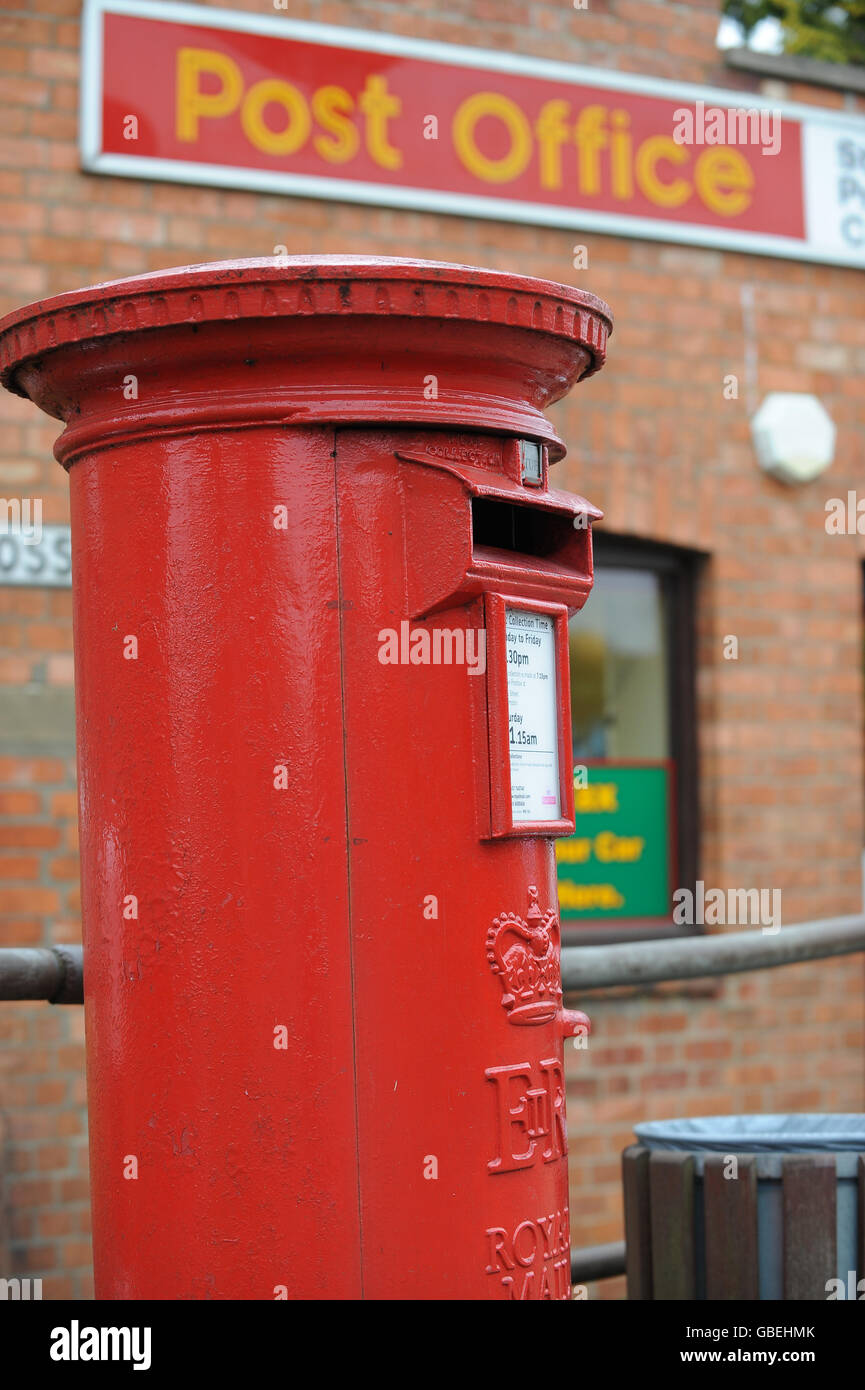 Royal Mail Post Box. Red Royal Mail Post Box at Cross Street, Moulton, Northamptonshire outside of the village Post Office. Stock Photo
