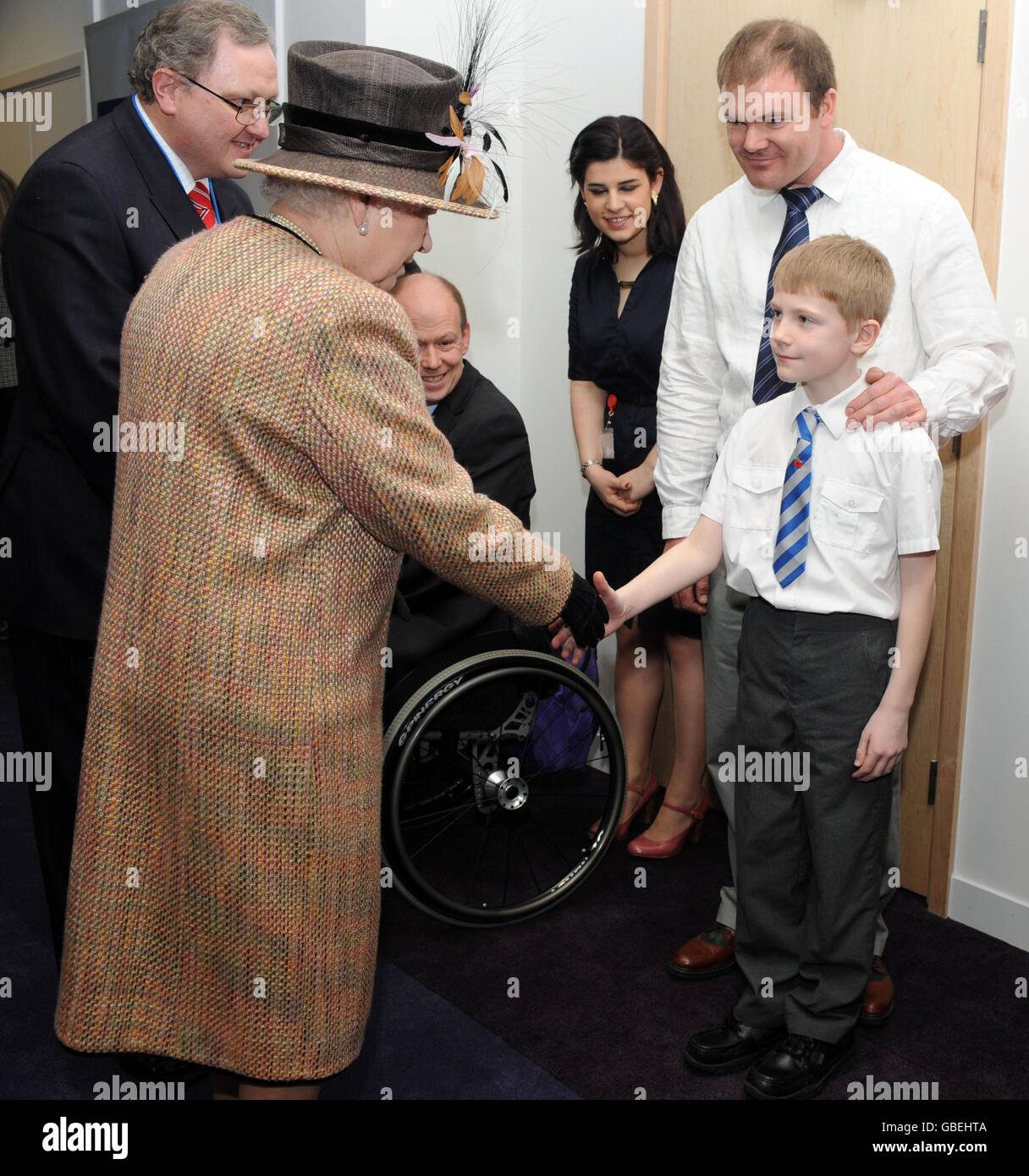 Queen Elizabeth II meets 9 year old George Taylor after she officially opened the new British Legion Headquarters in South London. Stock Photo