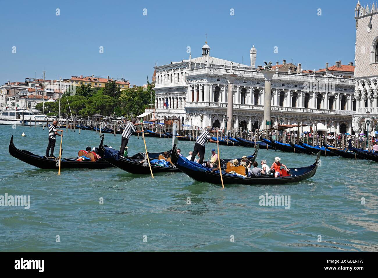 gondolas, tourists, gondoliers, Palazzo della Zecca, Palazzo Ducale, Doge's Palace, palace, Bacino di San Marco, Venice, Venezia, Veneto, Italy Stock Photo