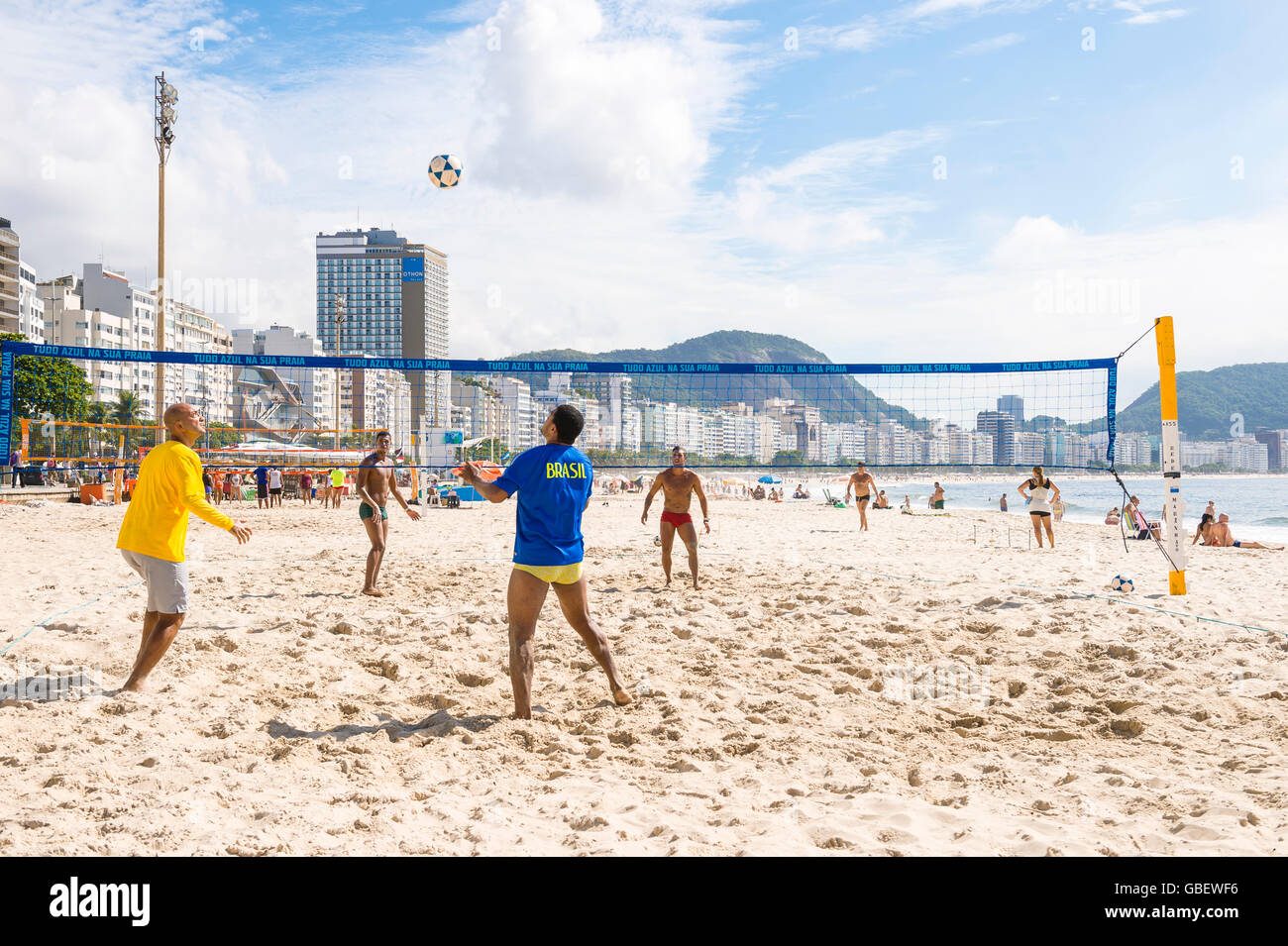RIO DE JANEIRO - MARCH 15, 2016: Brazilian men play a game of futevôlei (footvolley, a sport combining football and volleyball. Stock Photo
