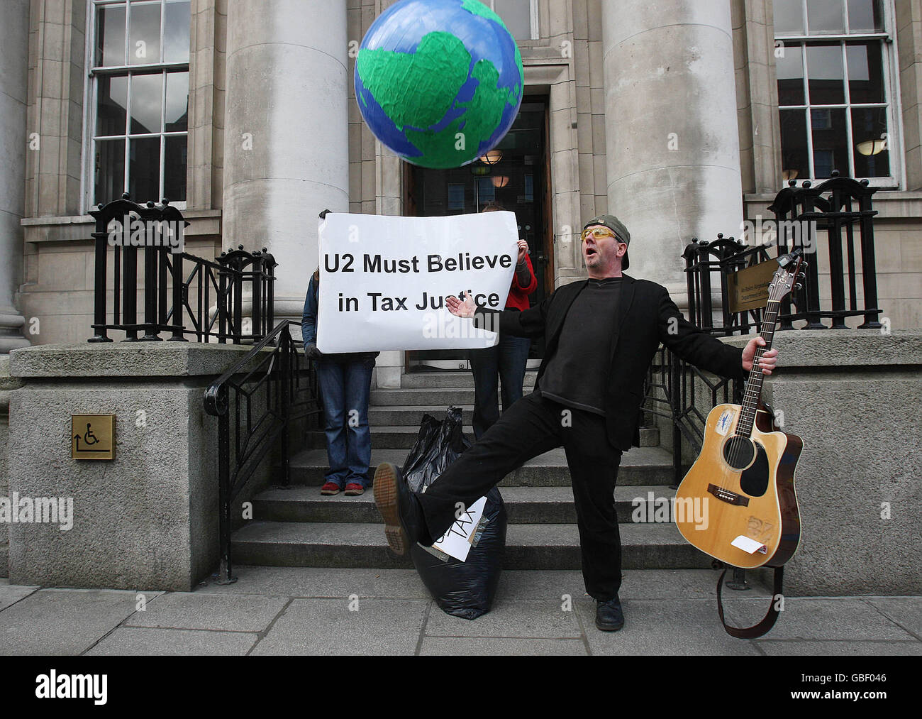 Members of the Debt and Development Coalition Ireland including Paul O'Toole (centre) dressed as Bono, the lead singer of U2, Protest outside the Department of Finance in Dublin on the eve of the launch of U2's new album 'No Line on the Horizon'. Stock Photo