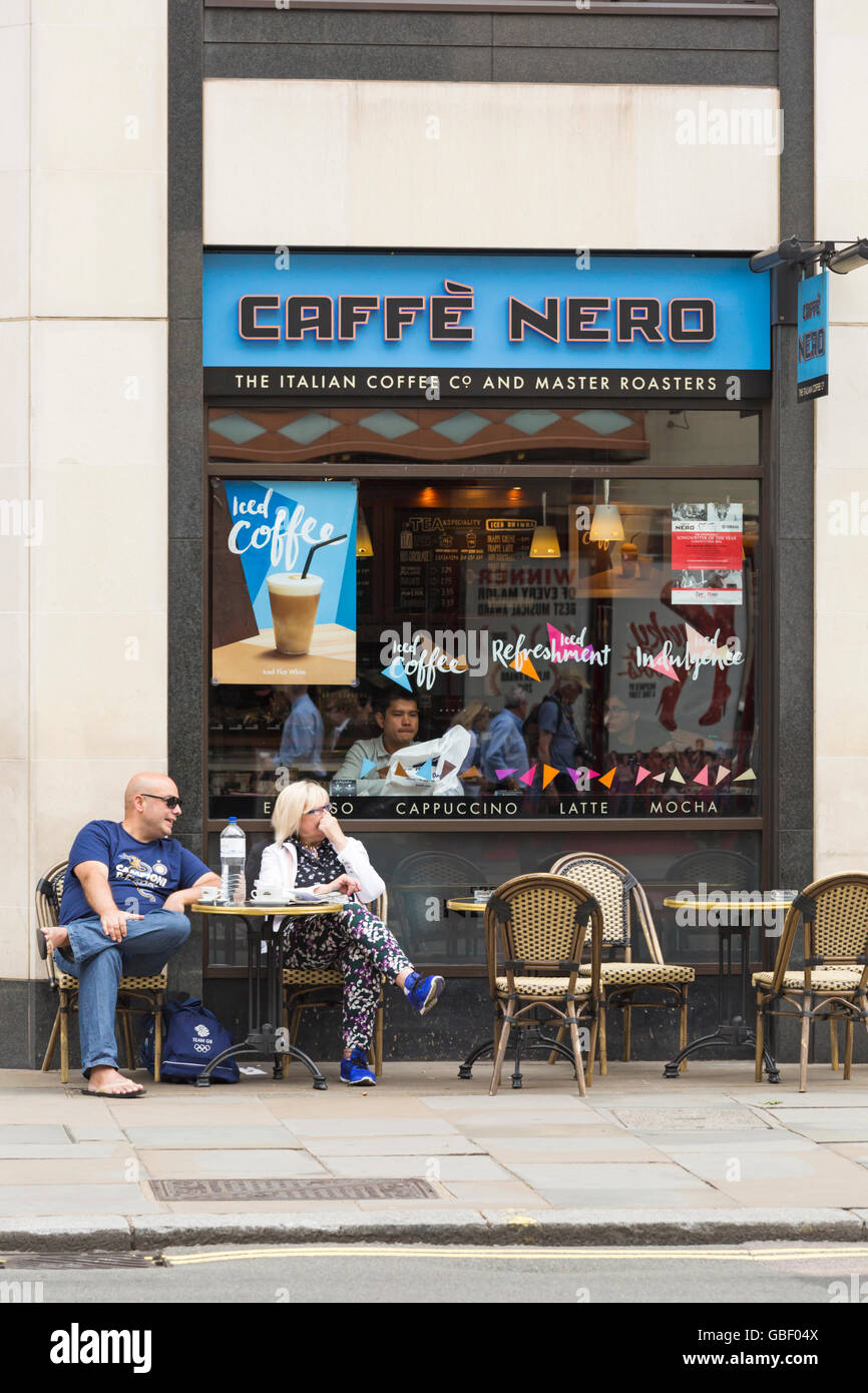 Couple relaxing outside Caffé Nero coffee shop at London, UK  in July Stock Photo