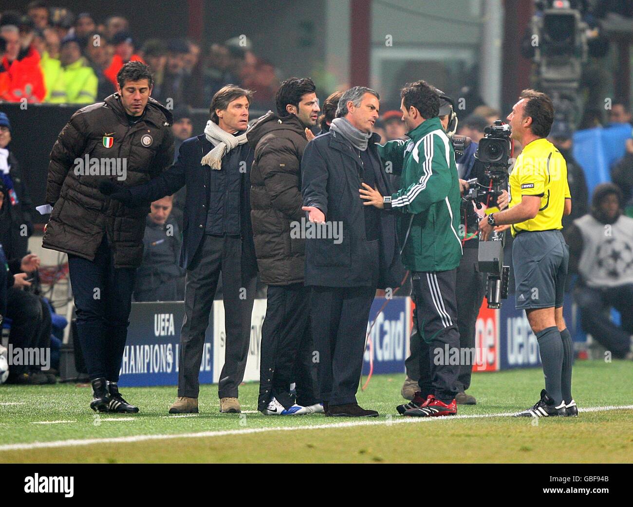 Inter Milan manager Jose Mourinho is held back by the fourth official as match referee Luis Medina Cantalejo prepares to give Inter Milan's reserve goalkeeper Francesco Toldo a Yellow card Stock Photo