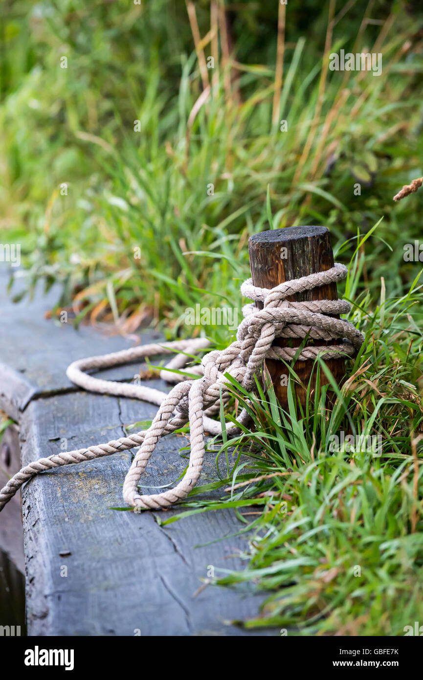 Mooring post with rope tied Stock Photo