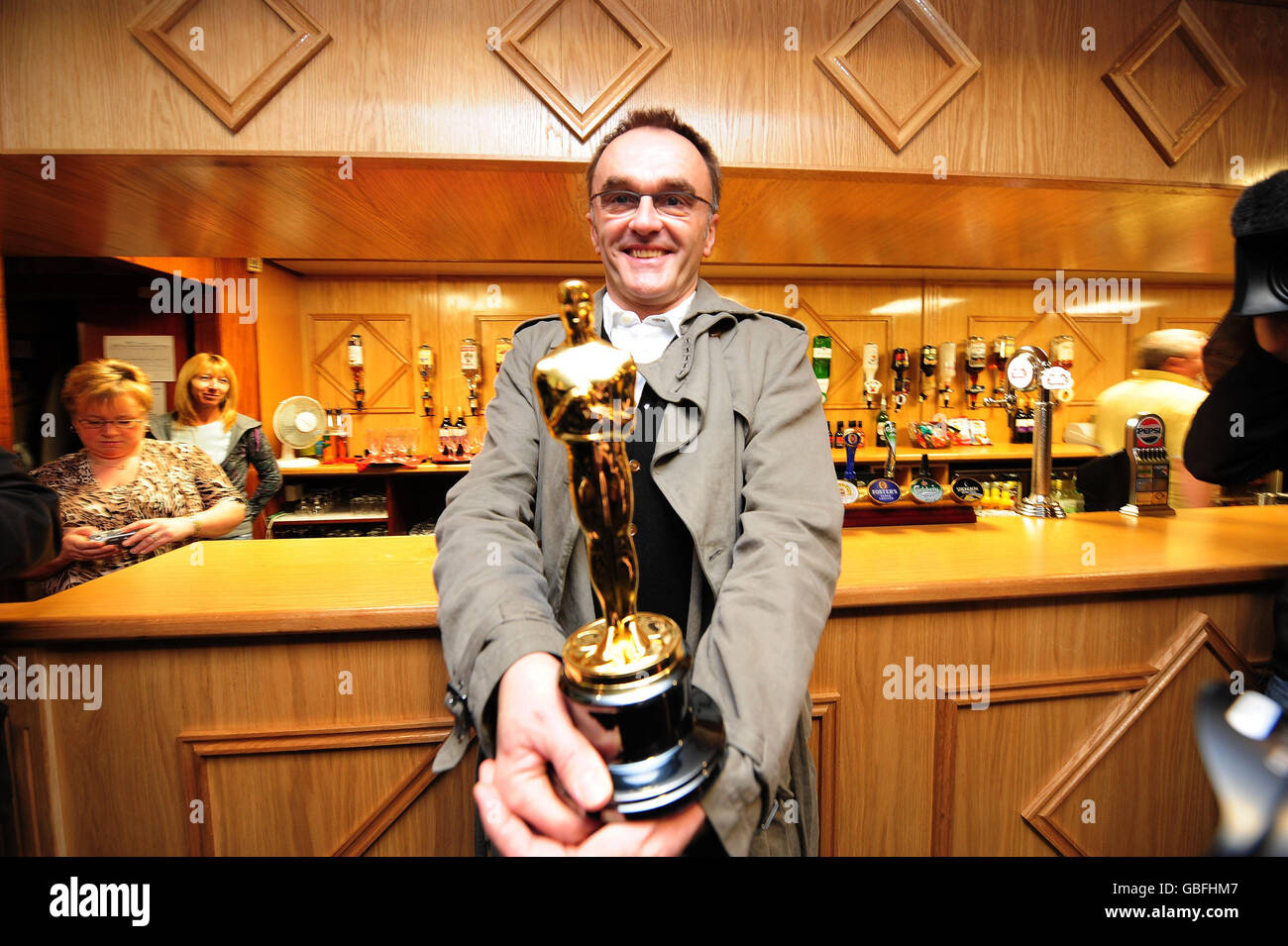 Director Danny Boyle holds his Oscars for Best Director at St Mary's Catholic Social Club in Radliffe near Manchester. Stock Photo