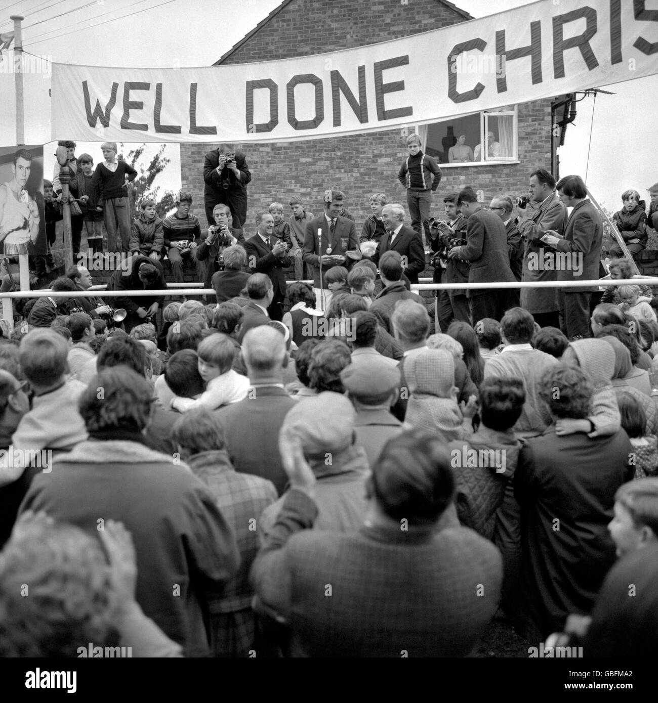 Olympic gold medallist boxer, Chris Finnegan (standing behind microphone) is shown on an open-air platform in his home town, Iver, Buckinghamshire, during the town's reception for him. Ron Hobbs, right, the Chairman of Iver Parish Council, had presented on their behalf, an 18 carat gold Hunter watch to the champion. Stock Photo