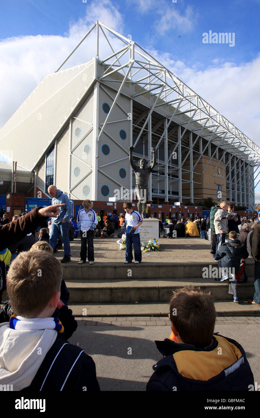 Fans gather outside Elland Road in front of a statue of Leeds United