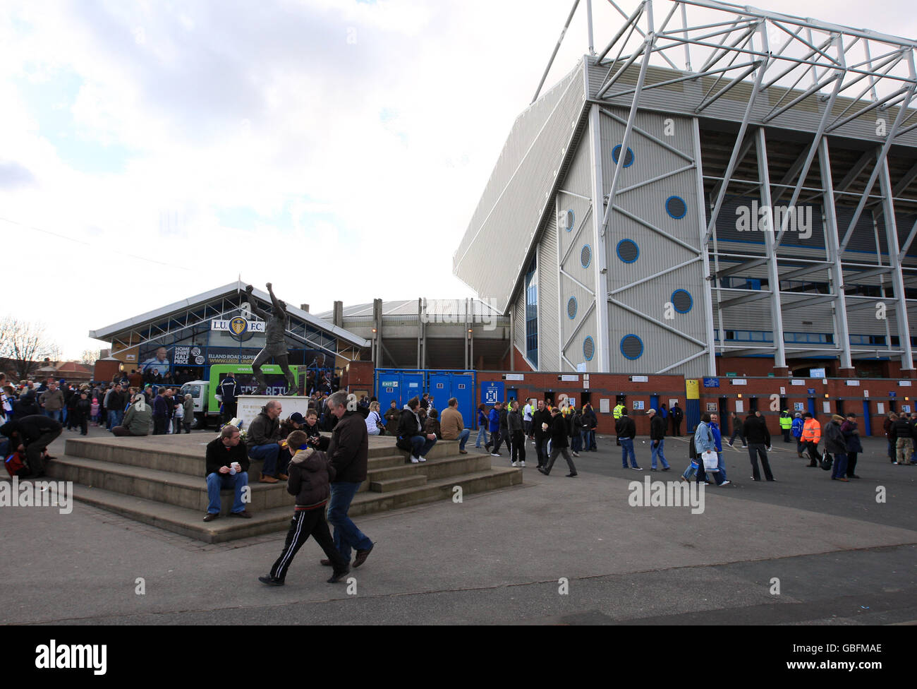 Fans gather outside Elland Road in front of a statue of Leeds United