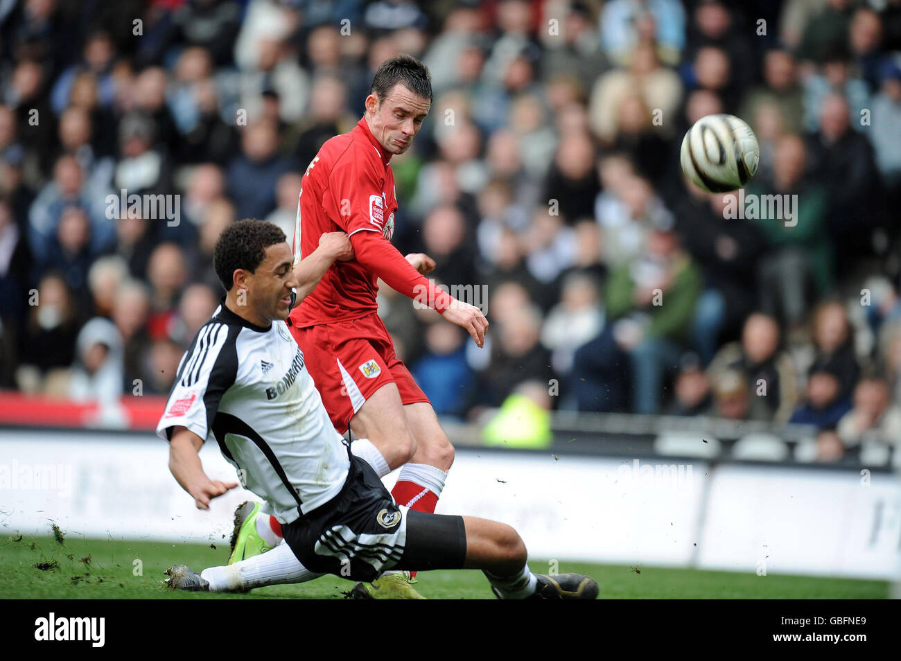 Derby County's Lewin Nyatanga slides in to tackle Bristol City's Michael McIndoe during the Coca-Cola Championship match at Pride Park, Derby. Stock Photo