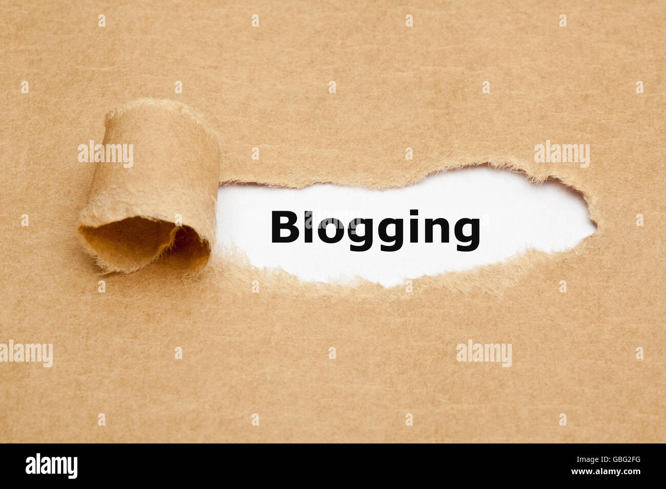 The word Blogging appearing behind ripped brown paper. Stock Photo