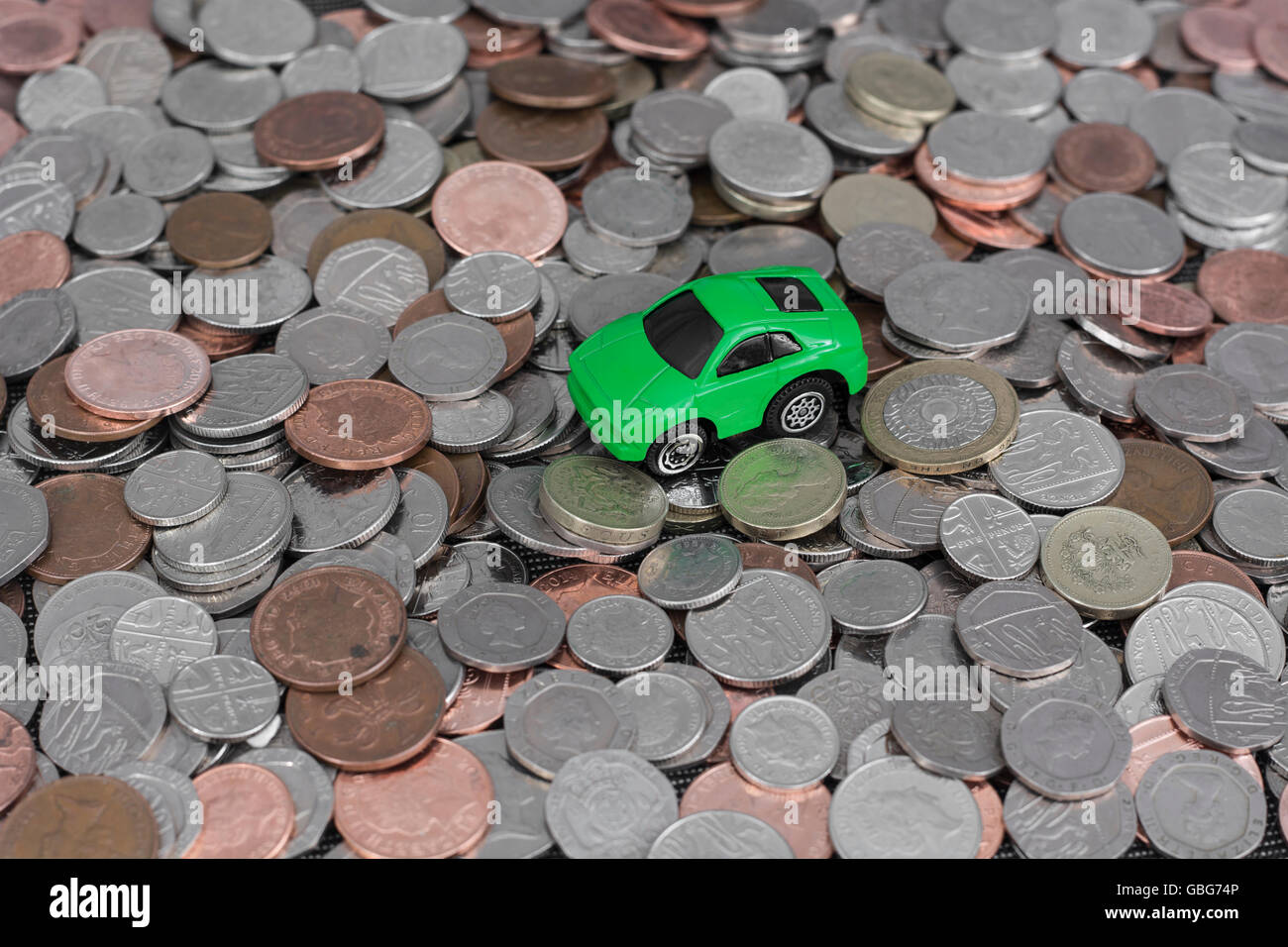 Motoring / car costs concept. Small toy car on top of a pile of