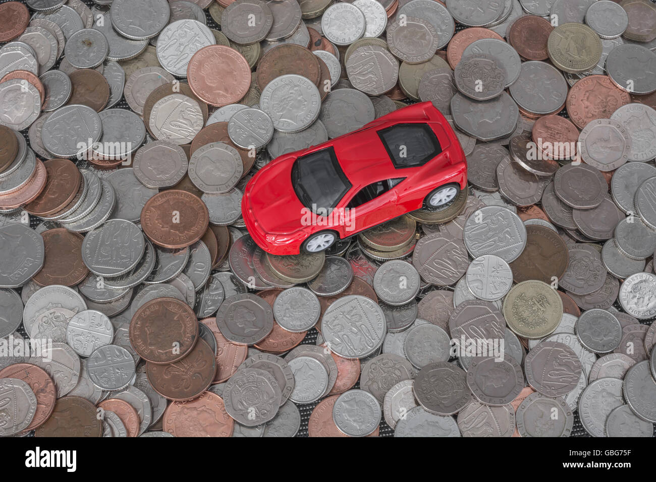 Motoring Car Costs Concept Small Toy Car On Top Of A Pile Of