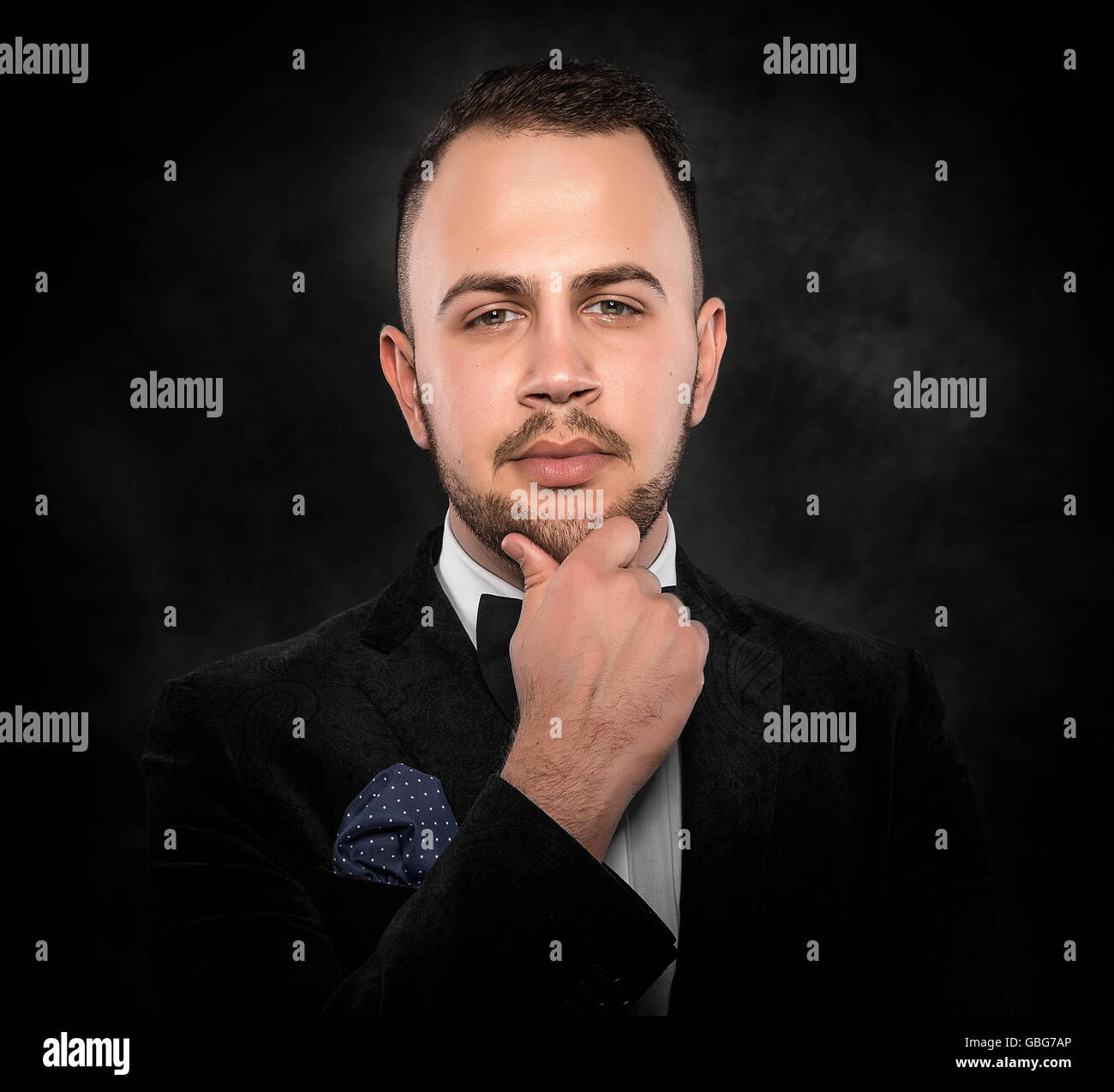 Young handsome man in black suit on dark background Stock Photo - Alamy