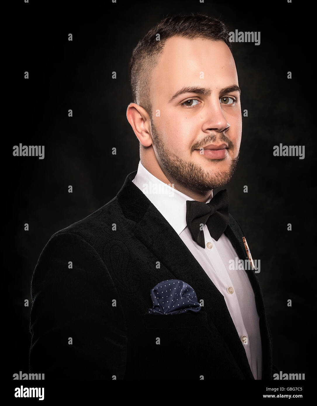 Young handsome man in black suit on dark background Stock Photo - Alamy