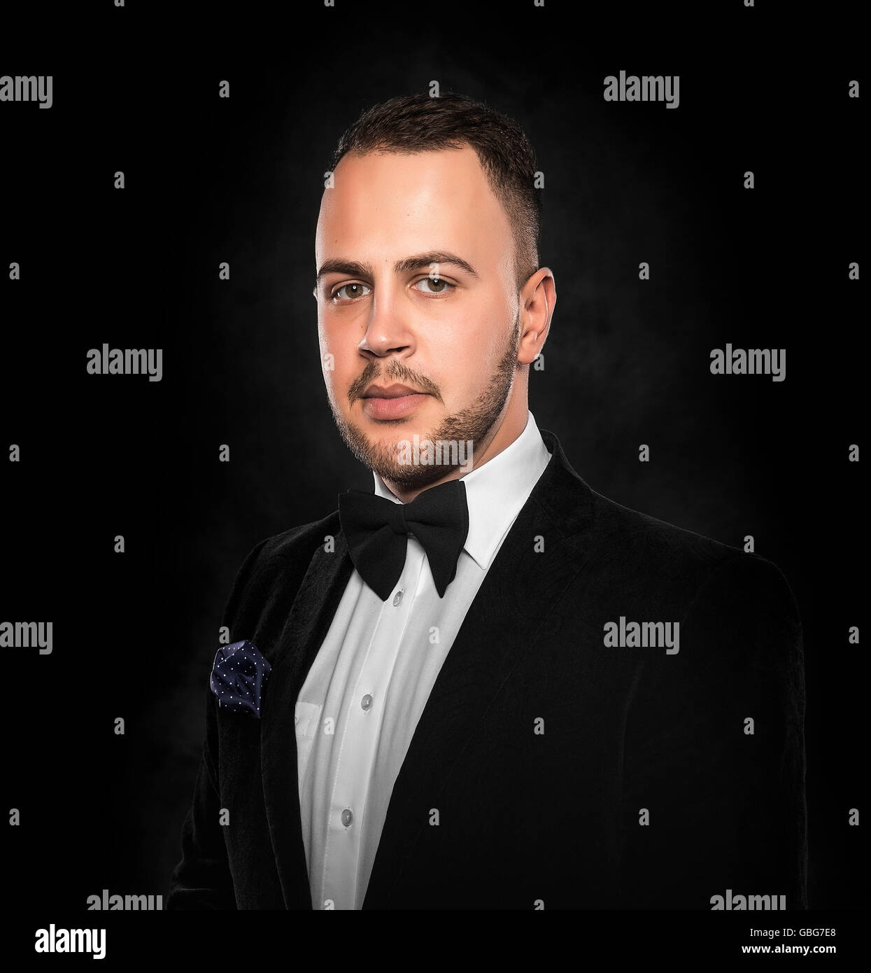 Young handsome man in black suit on dark background Stock Photo - Alamy
