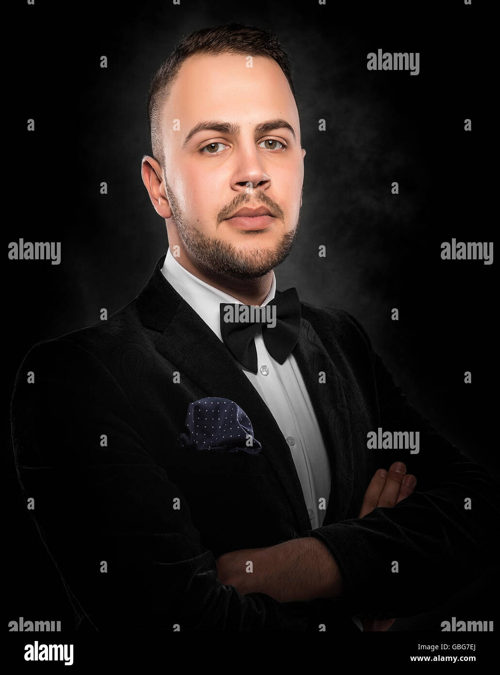 Young handsome man in black suit on dark background Stock Photo - Alamy