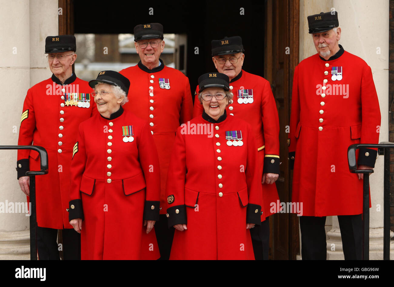 Winifred Phillips (front right) and Dorothy Hughes (front left) are welcomed by Chelsea Pensioners (back left to right) Lewis Prangle, Geoff Crowther, Ralph Dickinson and Alan Swain as the first women Chelsea pensioners at the Royal Hospital Chelsea in London. Stock Photo