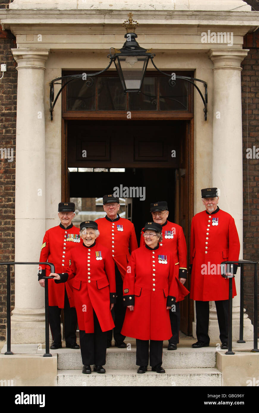 Winifred Phillips (front right) and Dorothy Hughes (front left) are welcomed by Chelsea Pensioners (back left to right) Lewis Prangle, Geoff Crowther, Ralph Dickinson and Alan Swain as the first women Chelsea pensioners at the Royal Hospital Chelsea in London. Stock Photo