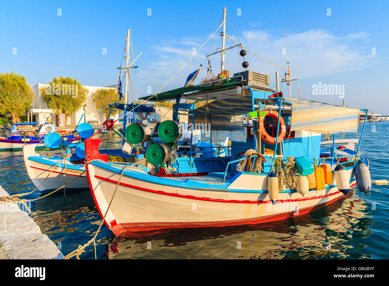 Traditional colourful Greek fishing boat in Pythagorion port at sunset ...