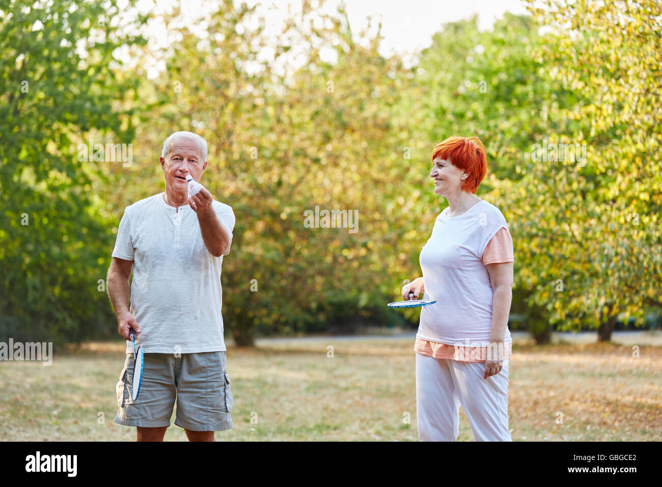 Senior couple playing badminton in the park in the garden Stock Photo