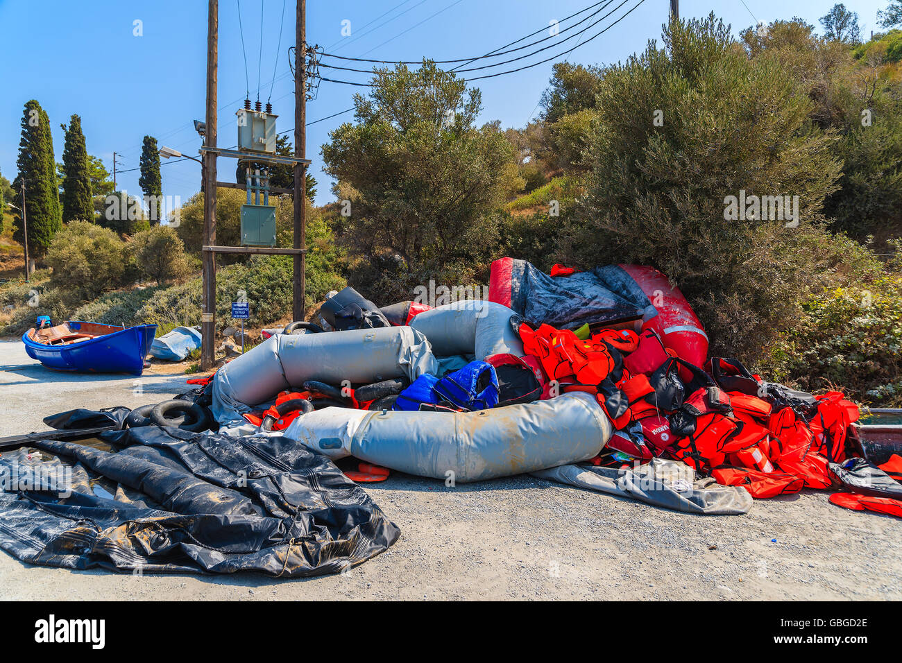 SAMOS ISLAND, GREECE - SEP 20, 2015: inflatable boats and life jackets on shore of Samos island, Greece. Refugees arrive here fr Stock Photo