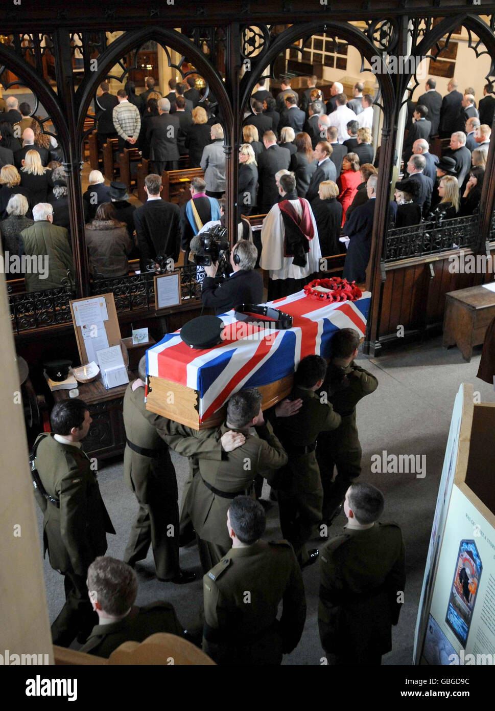 The coffin of Rifleman Jamie Gunn, 22, is carried into St Mary's Church in Monmouth for the funeral service. Rifleman Jamie Gunn, 22, was with Corporal Tom Gaden and Lance Corporal Paul Upton when their Land Rover was blown up by a makeshift explosive device in Helmand province on February 25. Stock Photo