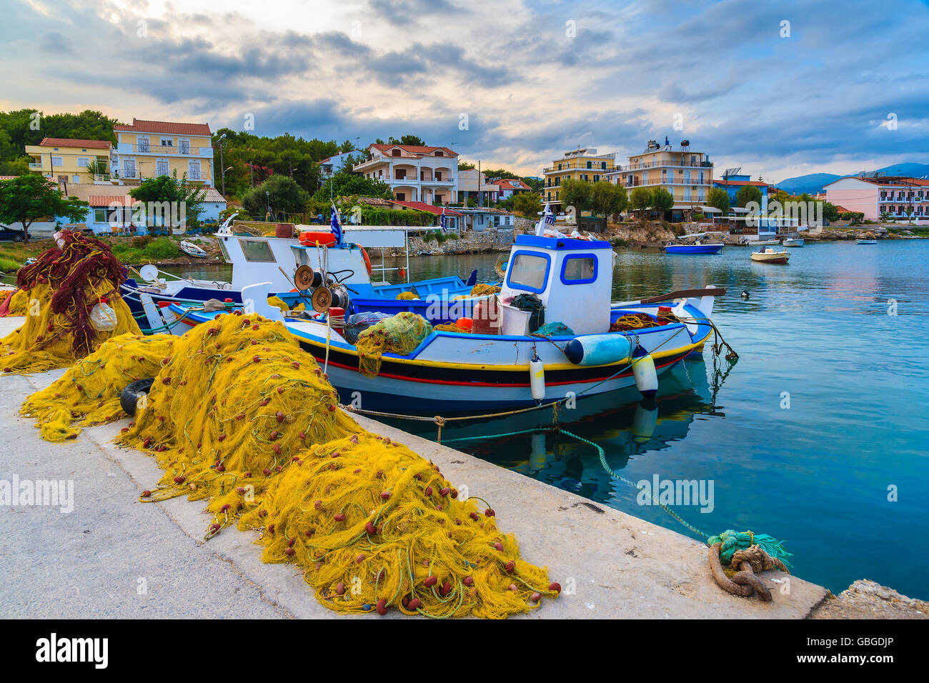 Colourful Greek fishing boats mooring in port at sunset time on Samos island, Greece Stock Photo